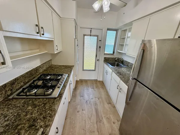 a kitchen with stainless steel appliances granite countertop a stove a refrigerator and a cabinets
