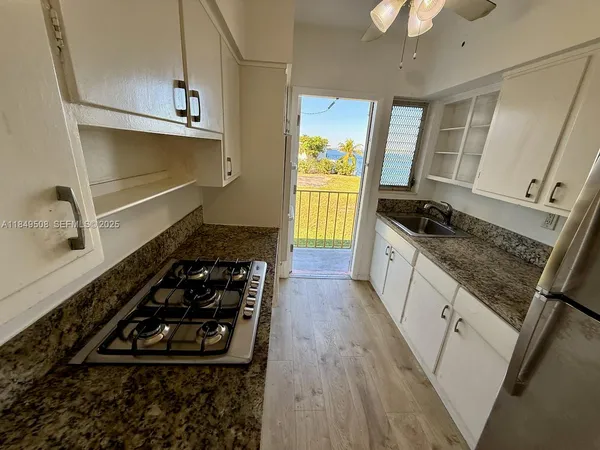 a kitchen with sink stove and cabinets