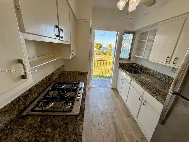 a kitchen with sink stove and cabinets