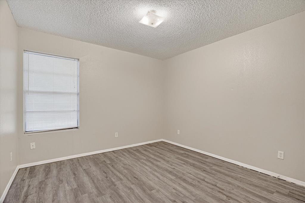 119 Del Rio Avenue, Unit C Benbrook, TX 76126 - Photo 10 of 17 wooden floor in an empty room with a window