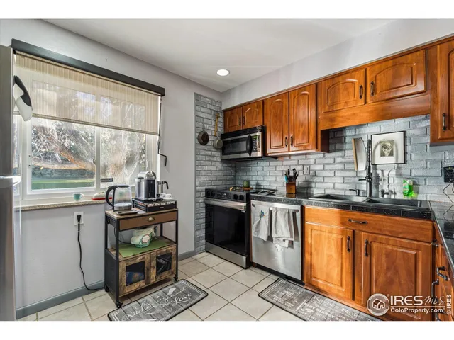 a kitchen with stainless steel appliances granite countertop a stove top oven a sink a counter space and cabinets