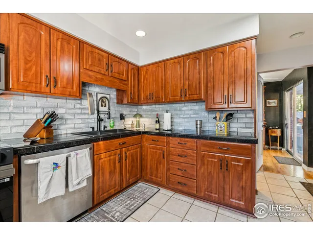 a kitchen with stainless steel appliances granite countertop a sink a stove cabinets counter space and a window