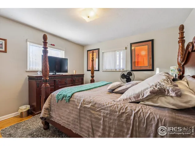 a bedroom with a bed window and a flat screen tv