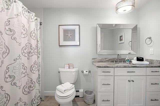 a bathroom with a granite countertop toilet sink and mirror