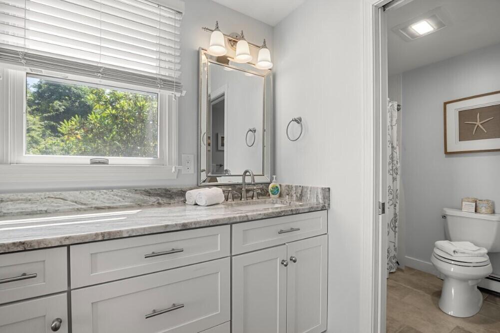 11 Fox Ridge Drive Orleans, MA 02653 - Photo 29 of 57 a bathroom with a granite countertop sink a toilet and a window