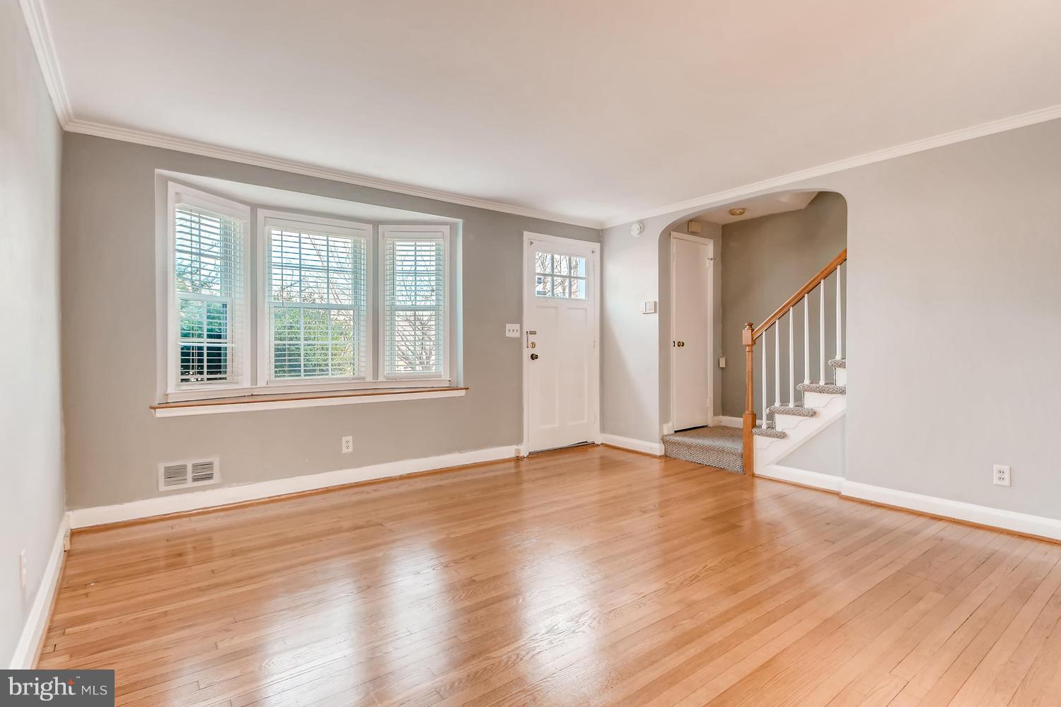 7013 Heathfield Road Baltimore, MD 21212 - Photo 6 of 33 a view of an empty room with wooden floor and a window