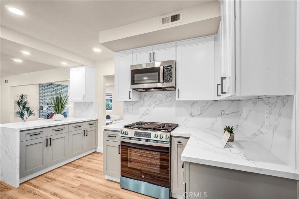 1355 Limerick Drive Placentia, CA 92870 - Photo 3 of 33 a kitchen with stainless steel appliances white cabinets and stove top oven