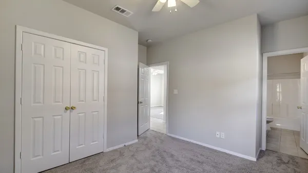 an empty room with windows and closet