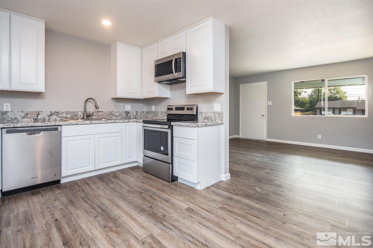 625 Akard Circle Reno, NV 89503 - Photo 8 of 27 a kitchen with stainless steel appliances granite countertop a stove top oven a sink dishwasher and a microwave with wooden floor