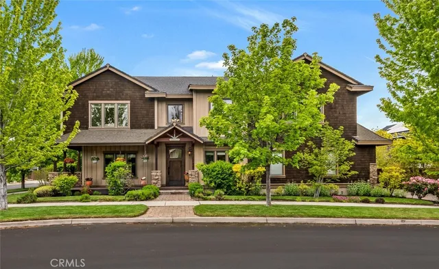 a front view of a house with a yard and trees