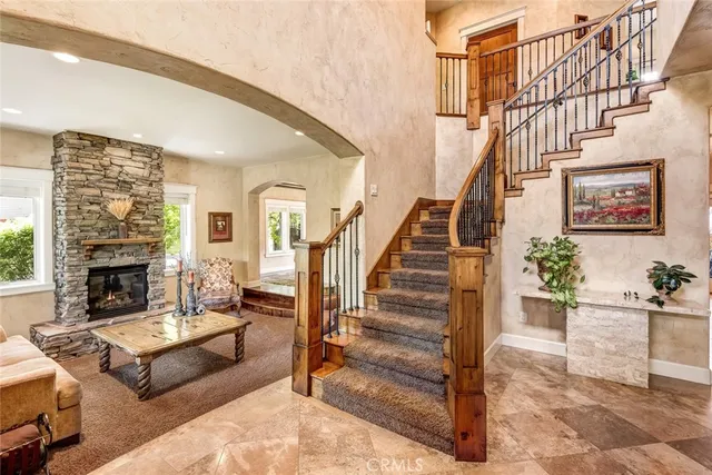 a living room with furniture a fireplace and a ceiling fan