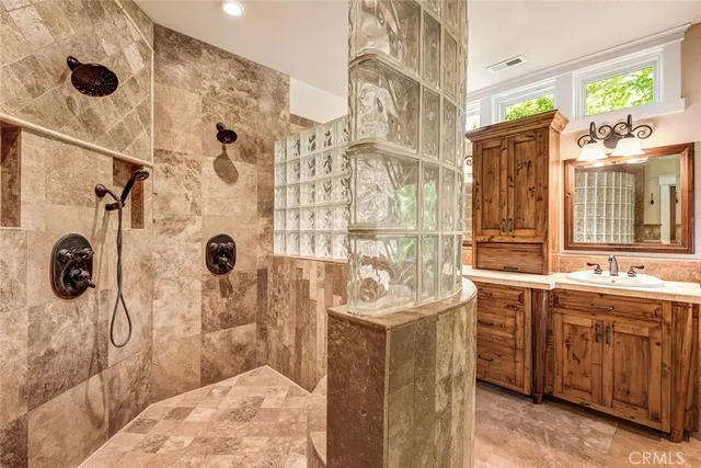a bathroom with a sink mirror and shower