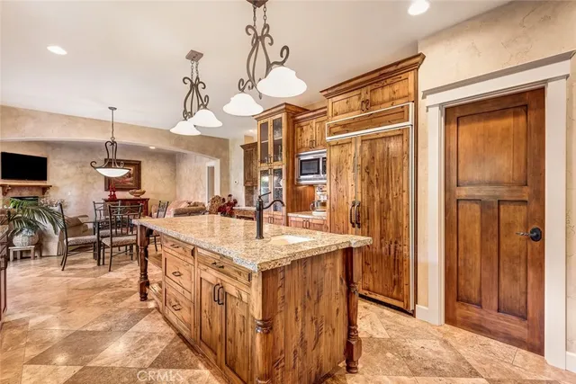 a large white kitchen with kitchen island a sink a stove and a chandelier
