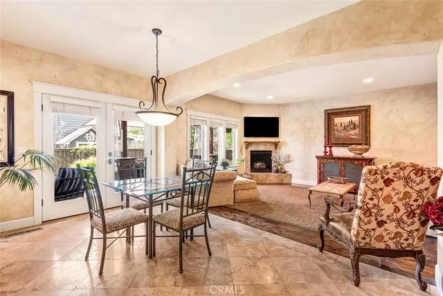 a dining room with furniture a chandelier and wooden floor