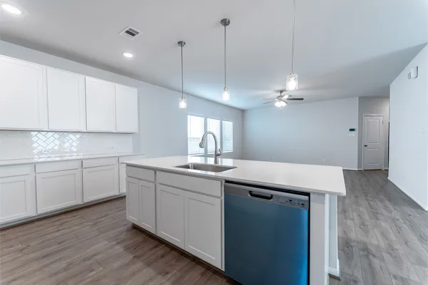 a kitchen with a sink cabinets and wooden floor