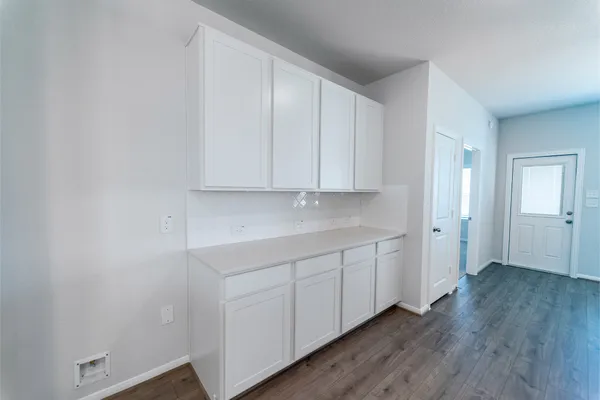 a view of an empty room with wooden floor and closet