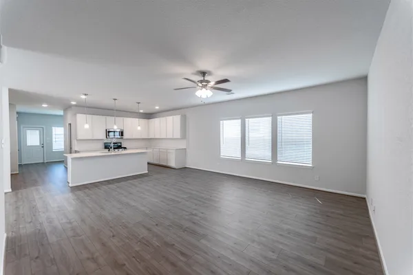 a view of a kitchen with a sink dishwasher a kitchen island with wooden floor and a kitchen