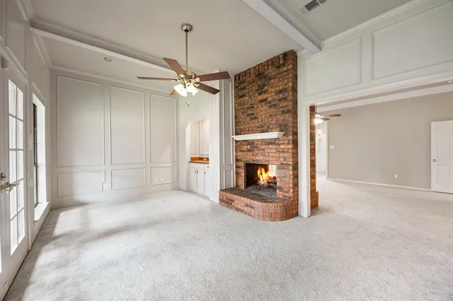 a view of a livingroom with a fireplace and a ceiling fan