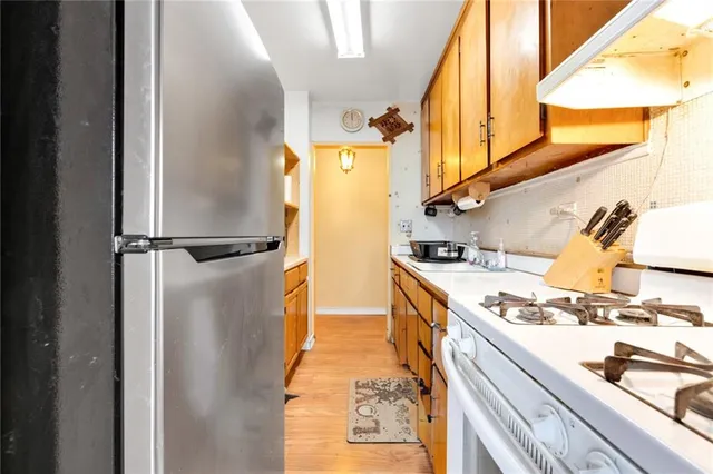 a kitchen with stainless steel appliances granite countertop a refrigerator and a stove