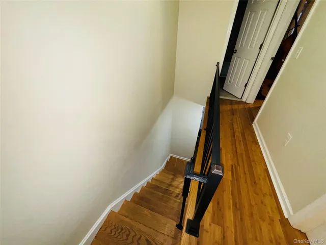 a view of staircase with wooden floor and a white wall