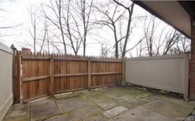 a view of backyard with wooden fence and large trees