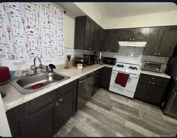 a kitchen with stainless steel appliances a sink dishwasher a stove a refrigerator and cabinets