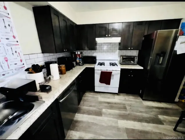 a kitchen with stainless steel appliances a sink stove and refrigerator