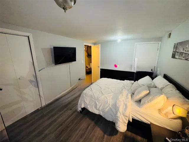a bedroom with a bed and flat screen tv