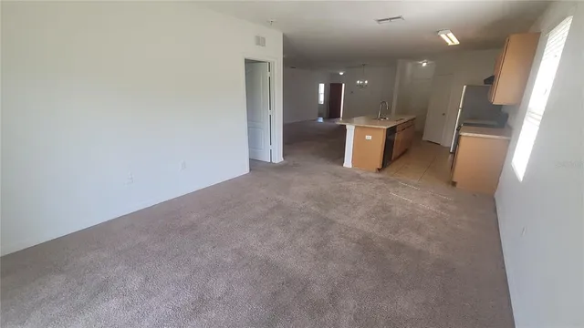 a view of an empty room with a kitchen