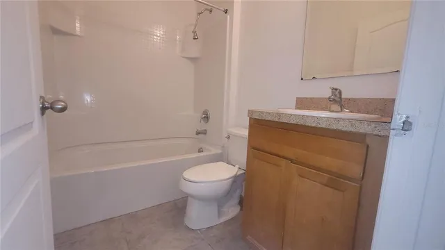 a bathroom with a granite countertop toilet a sink and bathtub
