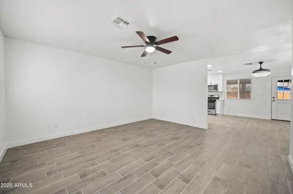 an empty room with closet and windows