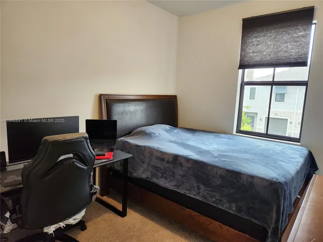 a bedroom with a bed dresser and a window