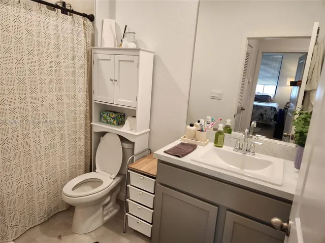 a bathroom with a toilet a sink and mirror