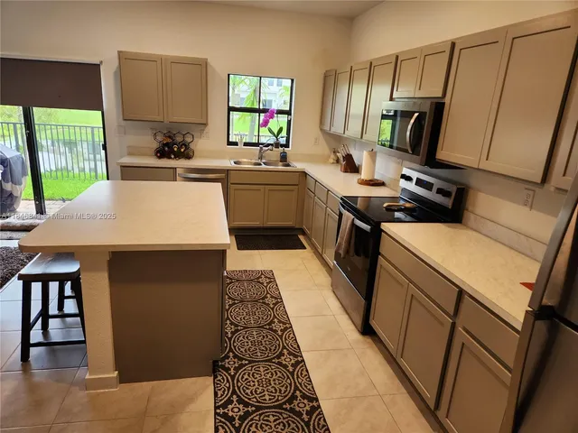 a kitchen with a sink appliances and cabinets