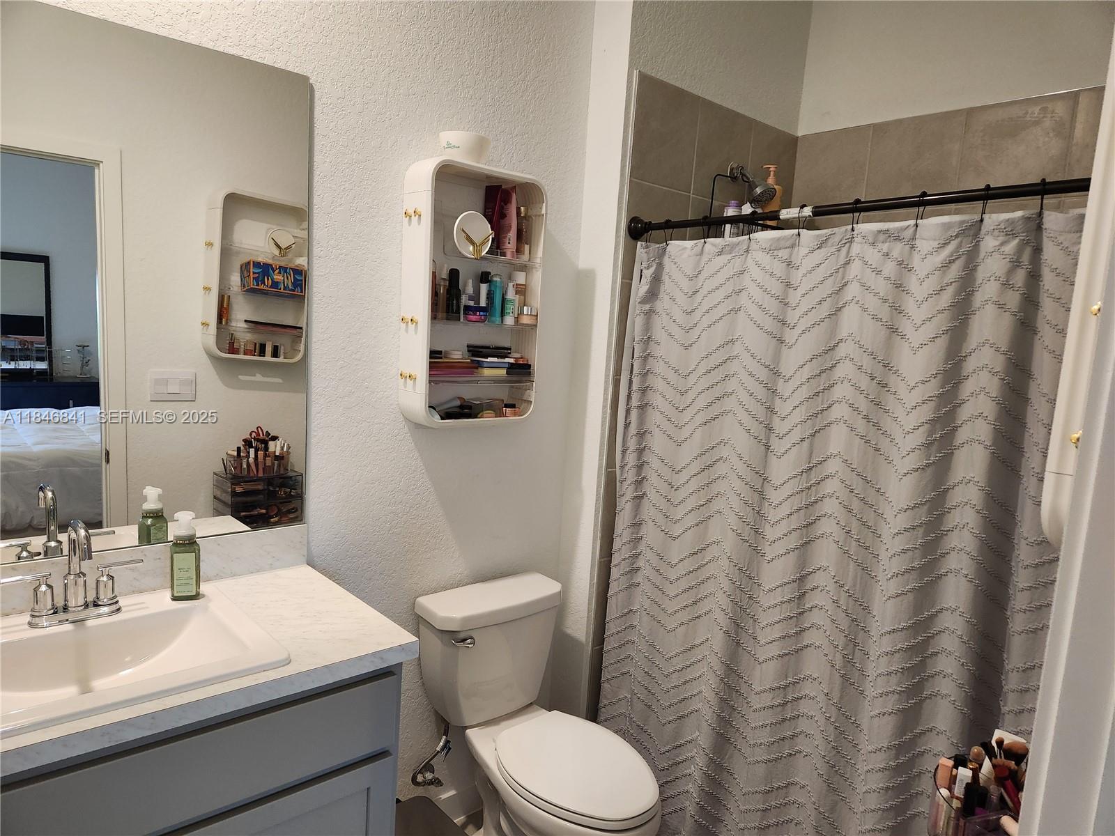 880 Northwest 3rd Way, Unit 880 Pompano Beach, FL 33060 - Photo 29 of 34 a bathroom with a sink a toilet and shower curtain