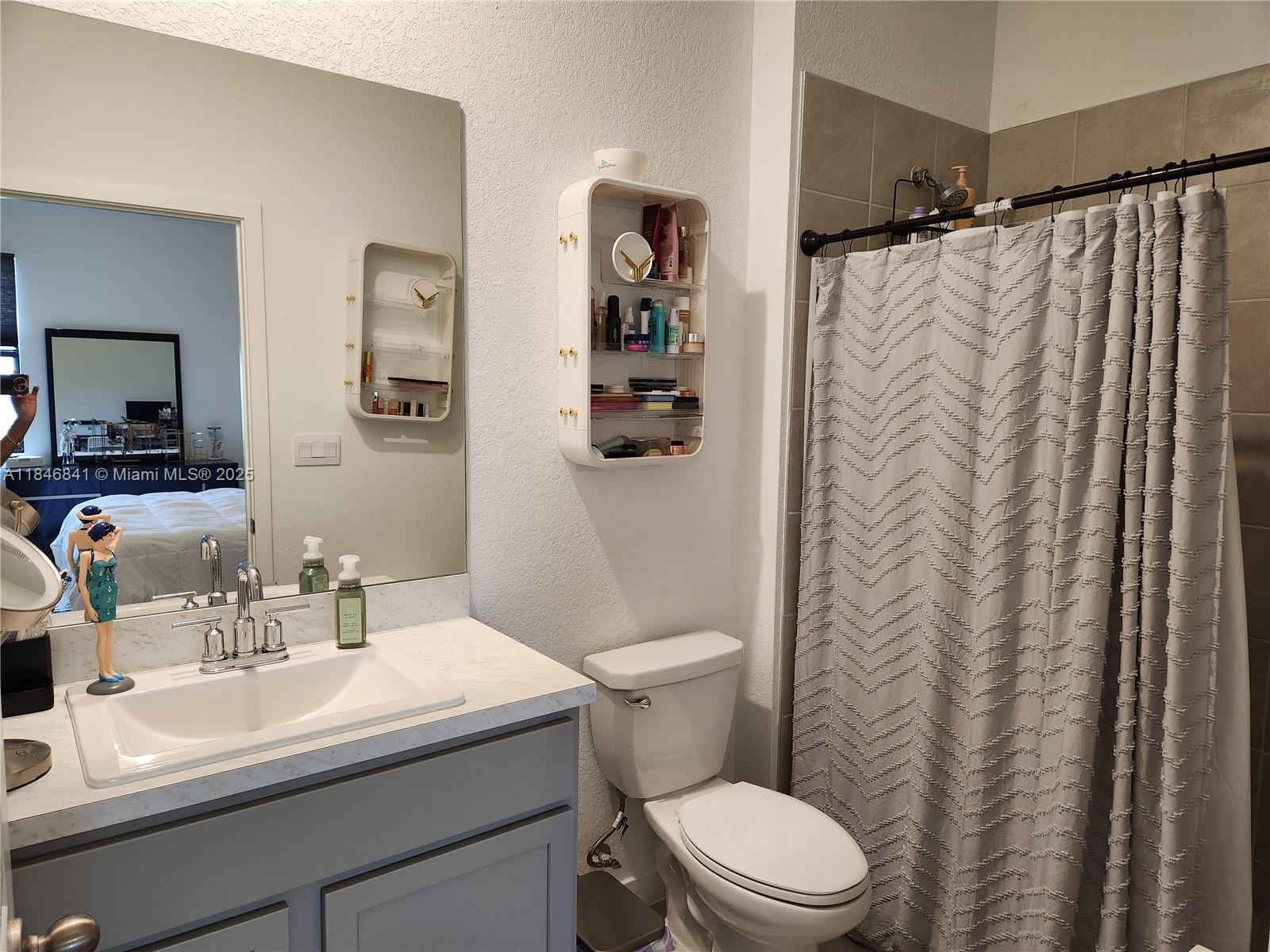 880 Northwest 3rd Way, Unit 880 Pompano Beach, FL 33060 - Photo 30 of 34 a bathroom with a sink a toilet and shower curtain
