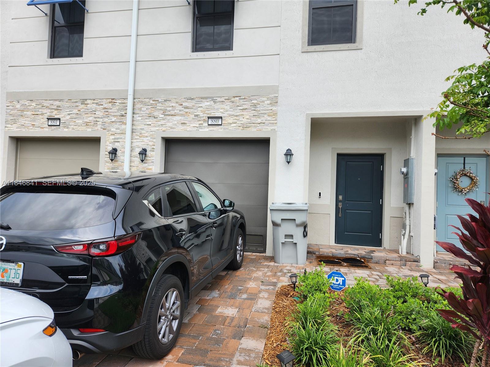 880 Northwest 3rd Way, Unit 880 Pompano Beach, FL 33060 - Photo 34 of 34 a front view of a house with parking space
