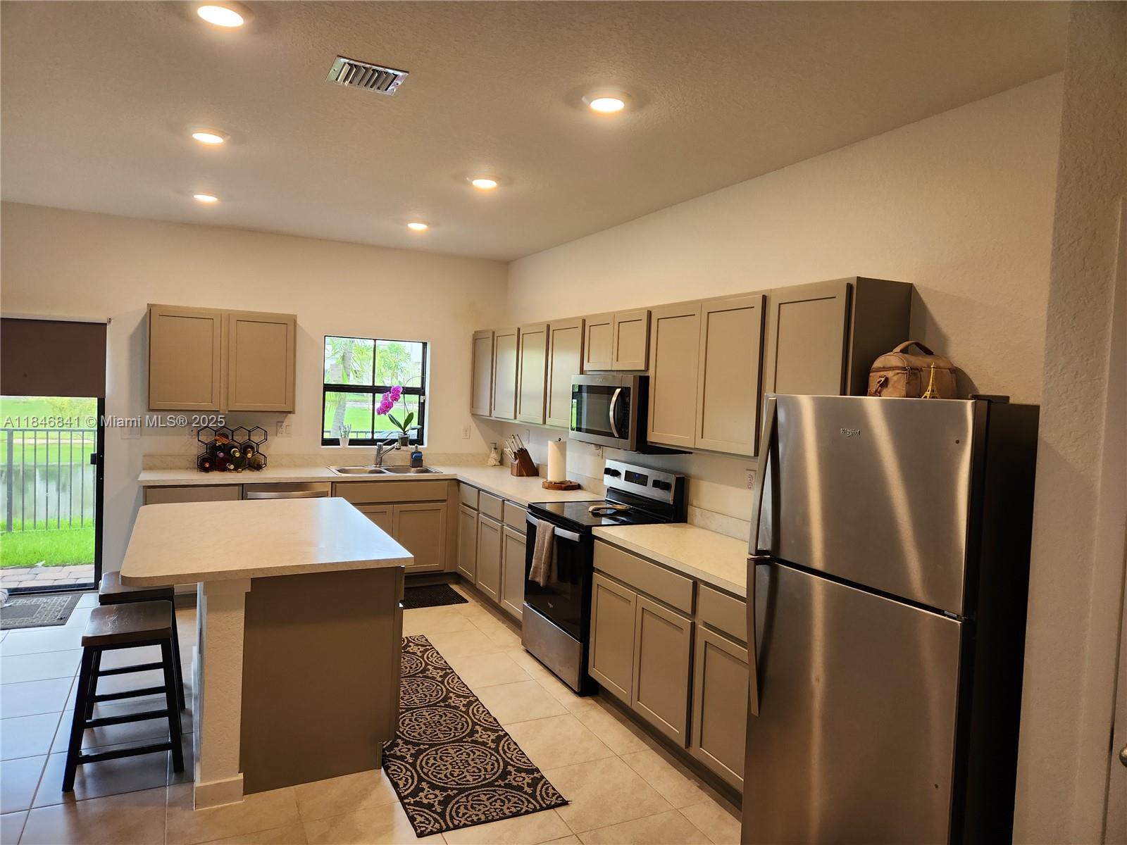 880 Northwest 3rd Way, Unit 880 Pompano Beach, FL 33060 - Photo 5 of 34 a kitchen with refrigerator and stove