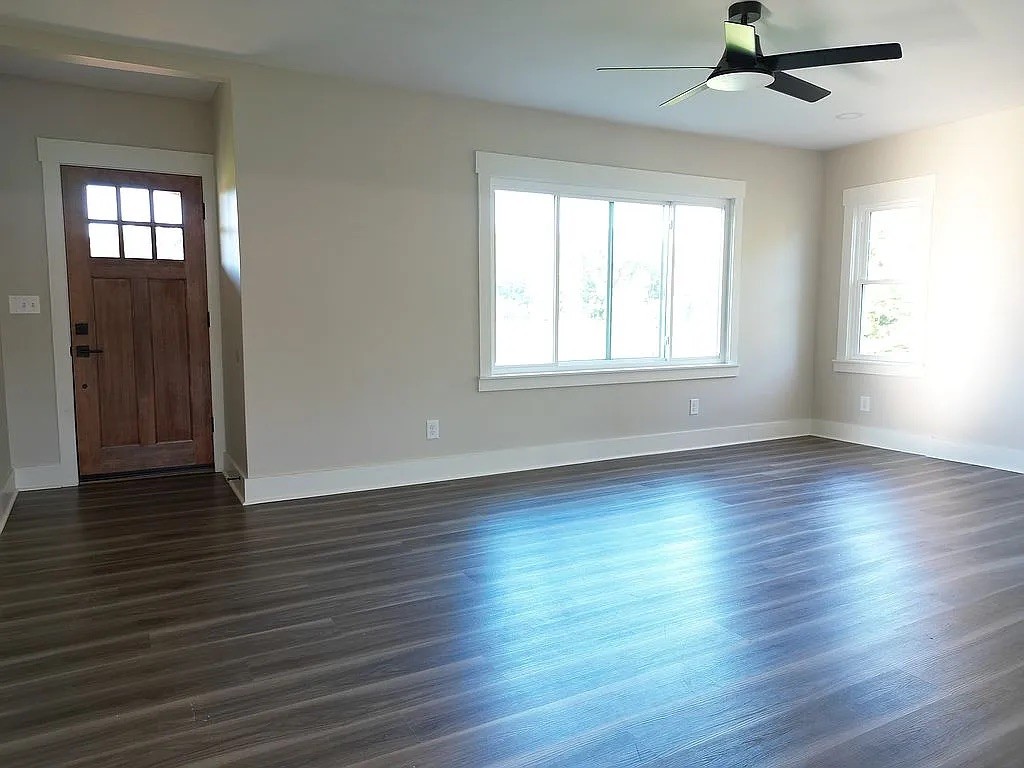 7140 Carthage Road Pleasant Shade, TN 37145 - Photo 7 of 36 an empty room with wooden floor chandelier fan and windows