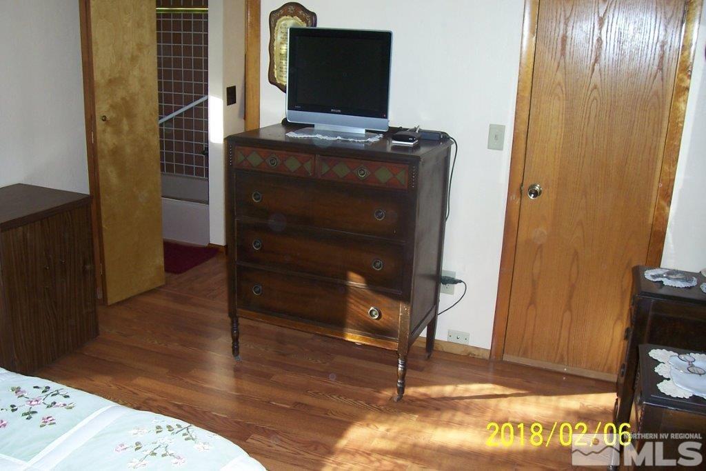 3700 Alcorn Road Fallon, NV 89406 - Photo 14 of 25 a view of a bedroom with wooden floor and wardrobe