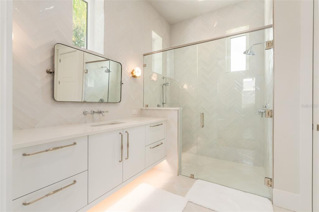 8679 Southwest 28 Lane Gainesville, FL 32608 - Photo 27 of 64 a bathroom with a double vanity sink mirror and shower