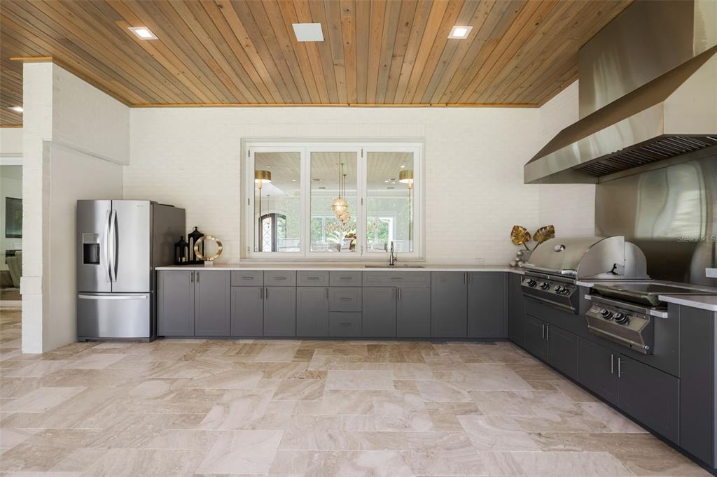 8679 Southwest 28 Lane Gainesville, FL 32608 - Photo 50 of 64 a kitchen with stainless steel appliances kitchen island granite countertop a refrigerator stove and sink