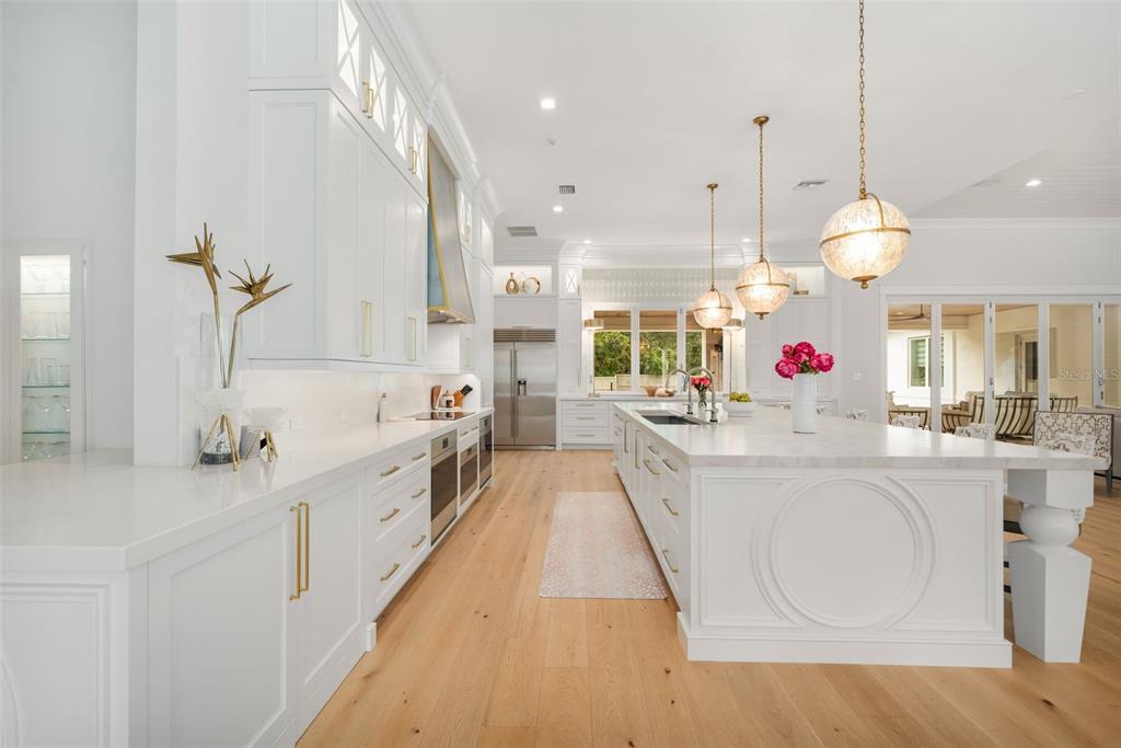 8679 Southwest 28 Lane Gainesville, FL 32608 - Photo 7 of 64 a large white kitchen with lots of counter space and chandelier