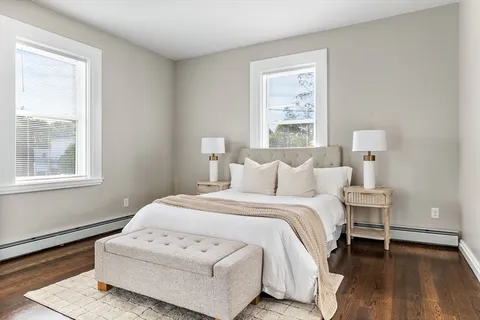 a bedroom with a white bed and white wooden floor
