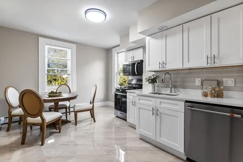 a kitchen with granite countertop cabinets a dining table and chairs