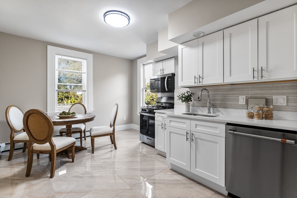 62 Chestnut Street, Unit 4 Saugus, MA 01906 - Photo 4 of 16 a kitchen with granite countertop cabinets a dining table and chairs