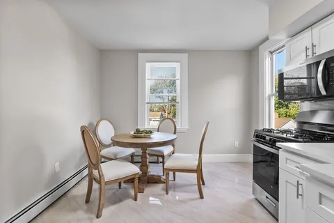 a view of a dining room with furniture and a window