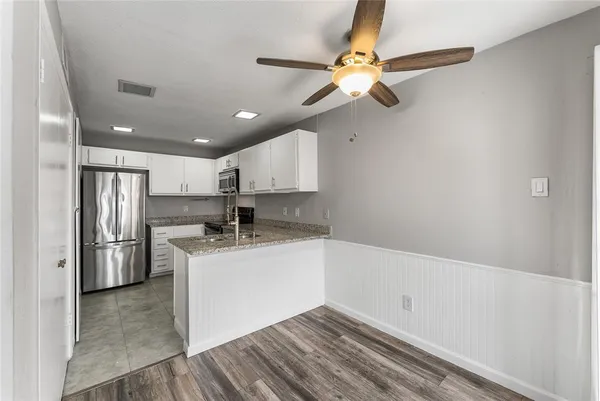 a kitchen with stainless steel appliances a sink cabinets and a refrigerator