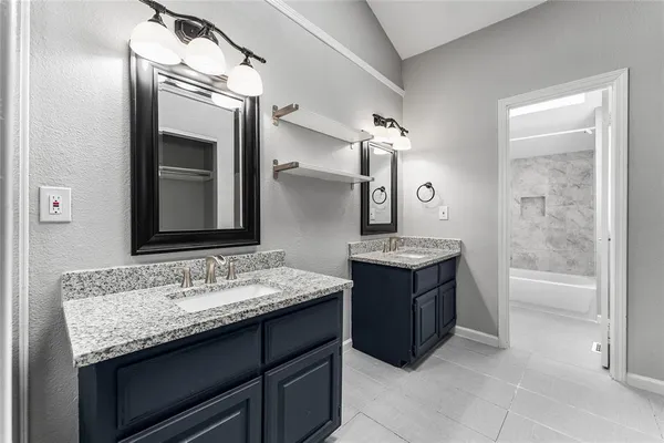 a bathroom with a granite countertop bathtub sink and mirror