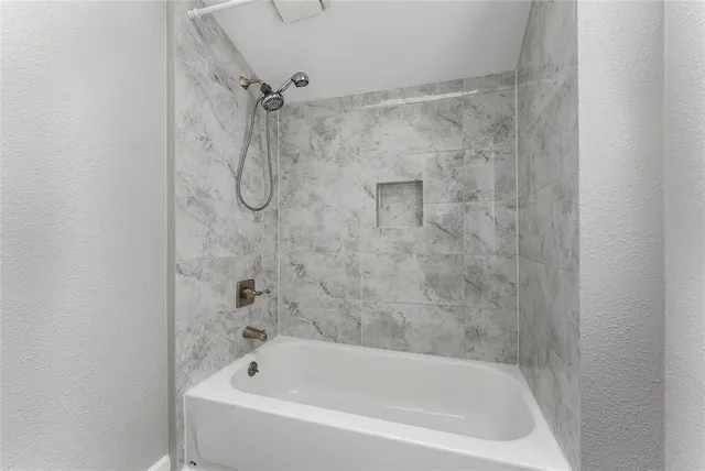 a white bath tub sitting next to a shower